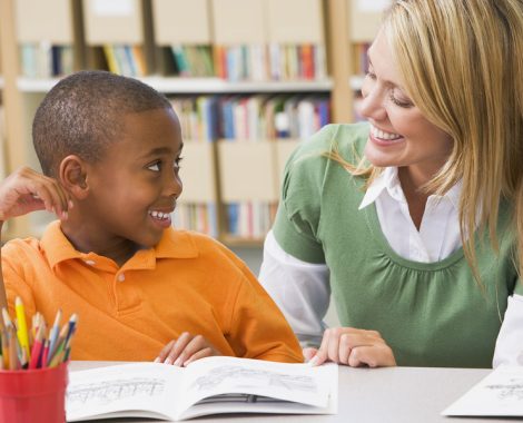 Happy Student Reading with Teacher